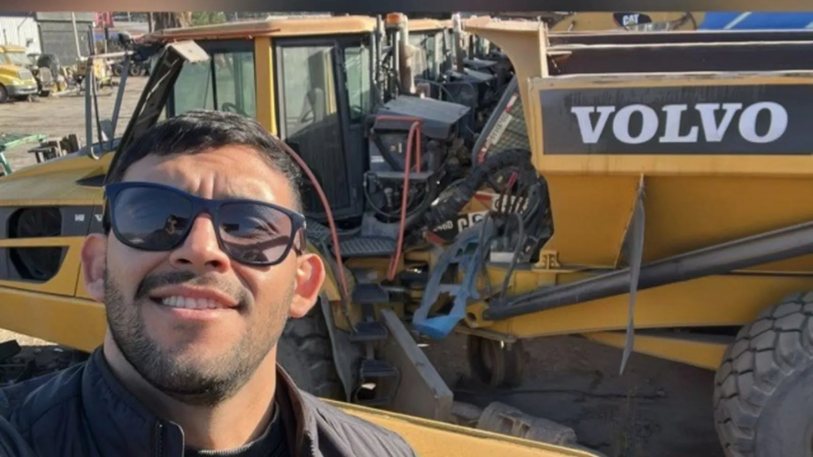 Rodrigo Gaete Pereira en terreno, junto a maquinaria pesada en un patio de equipos